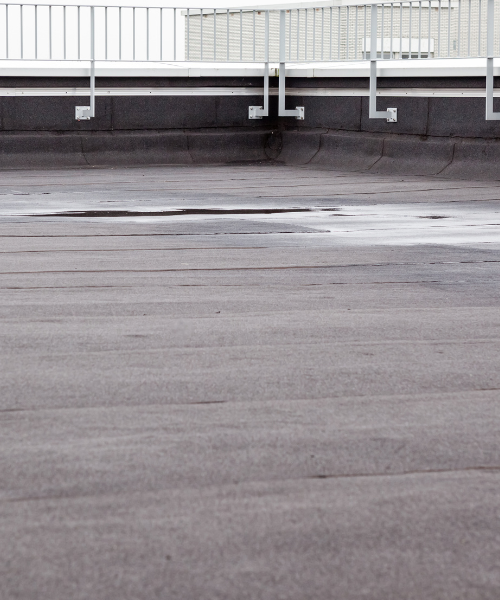 A man riding a skateboard on top of an empty parking lot