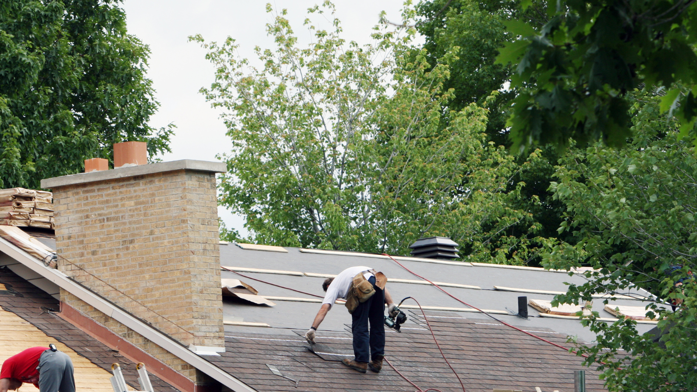 A man working on the roof of a house