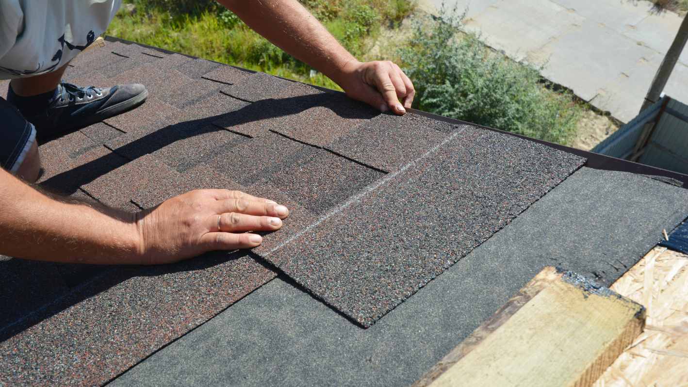 A man working on the roof of a house