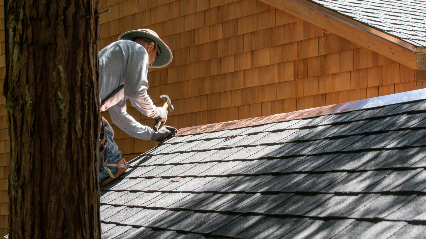 A man working on a roof with a hammer